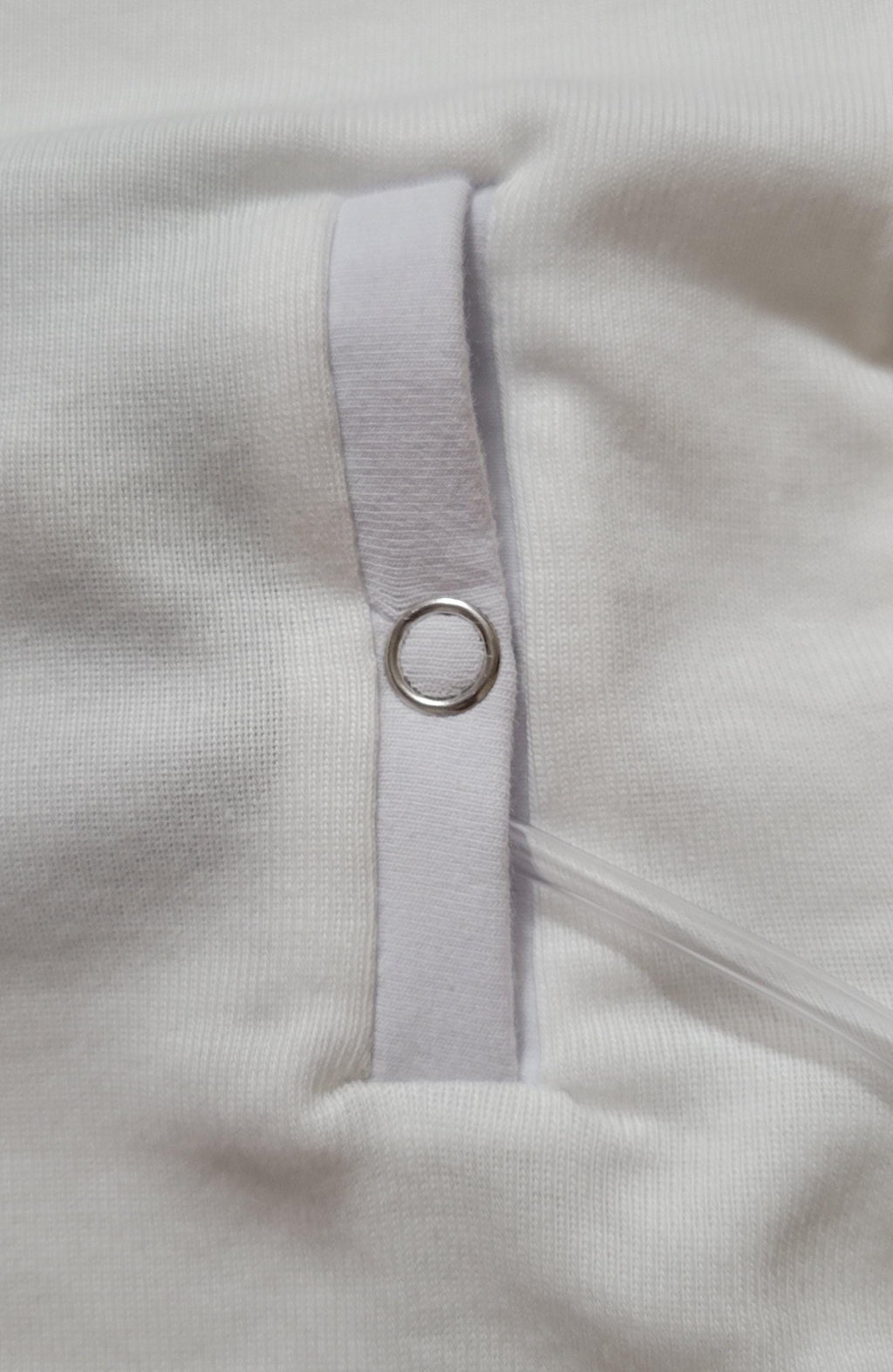 Close-up of a slit style gtube adaptation on a Childs clothing with a snap.