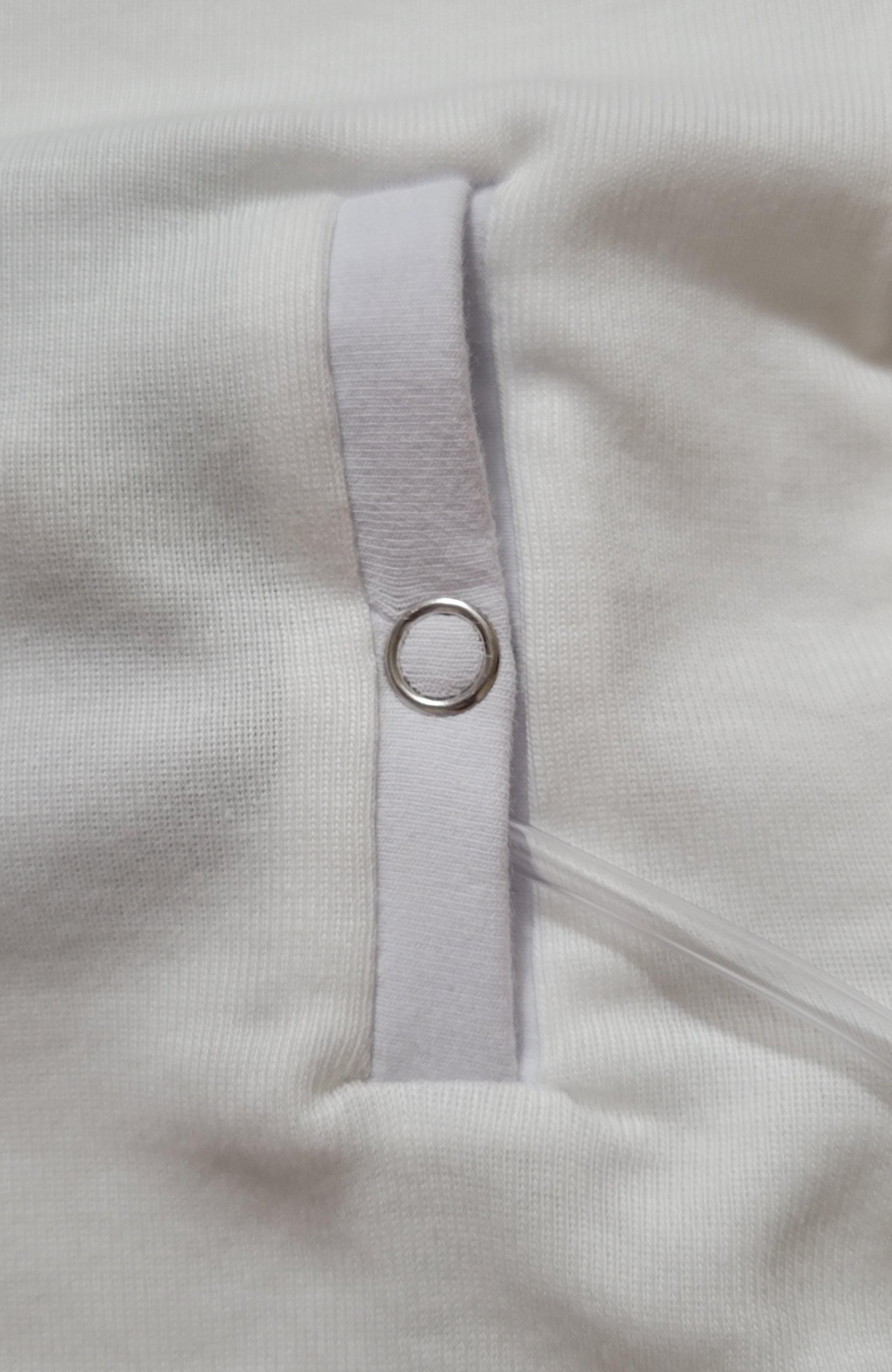 Close-up of a slit style gtube adaptation on a Childs clothing with a snap.