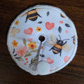 Mini gtube pad on white background with flowers, pink hearts and bees
