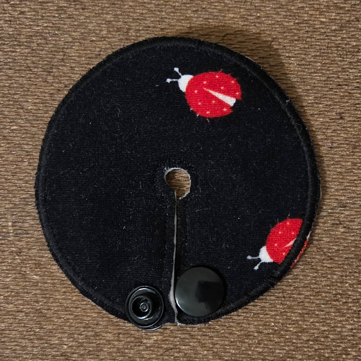 Mini gtube pad with red ladybugs on solid black background