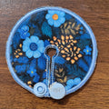 mini gtube pad in blue floral with small gold floral spray on black background