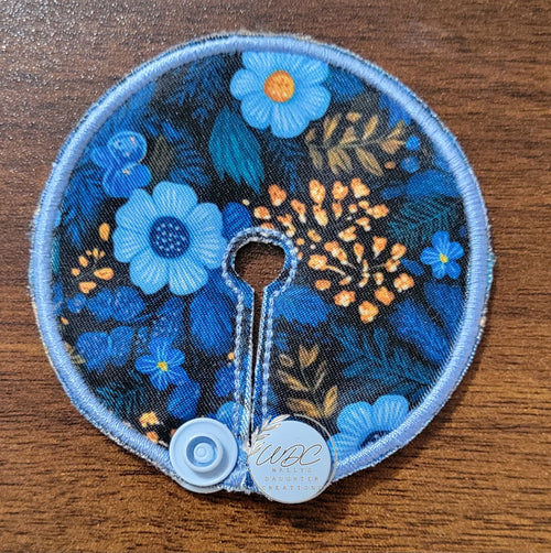 mini gtube pad in blue floral with small gold floral spray on black background