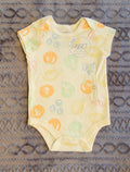 gtube adapted Baby onesie with fruit pattern on a textured surface