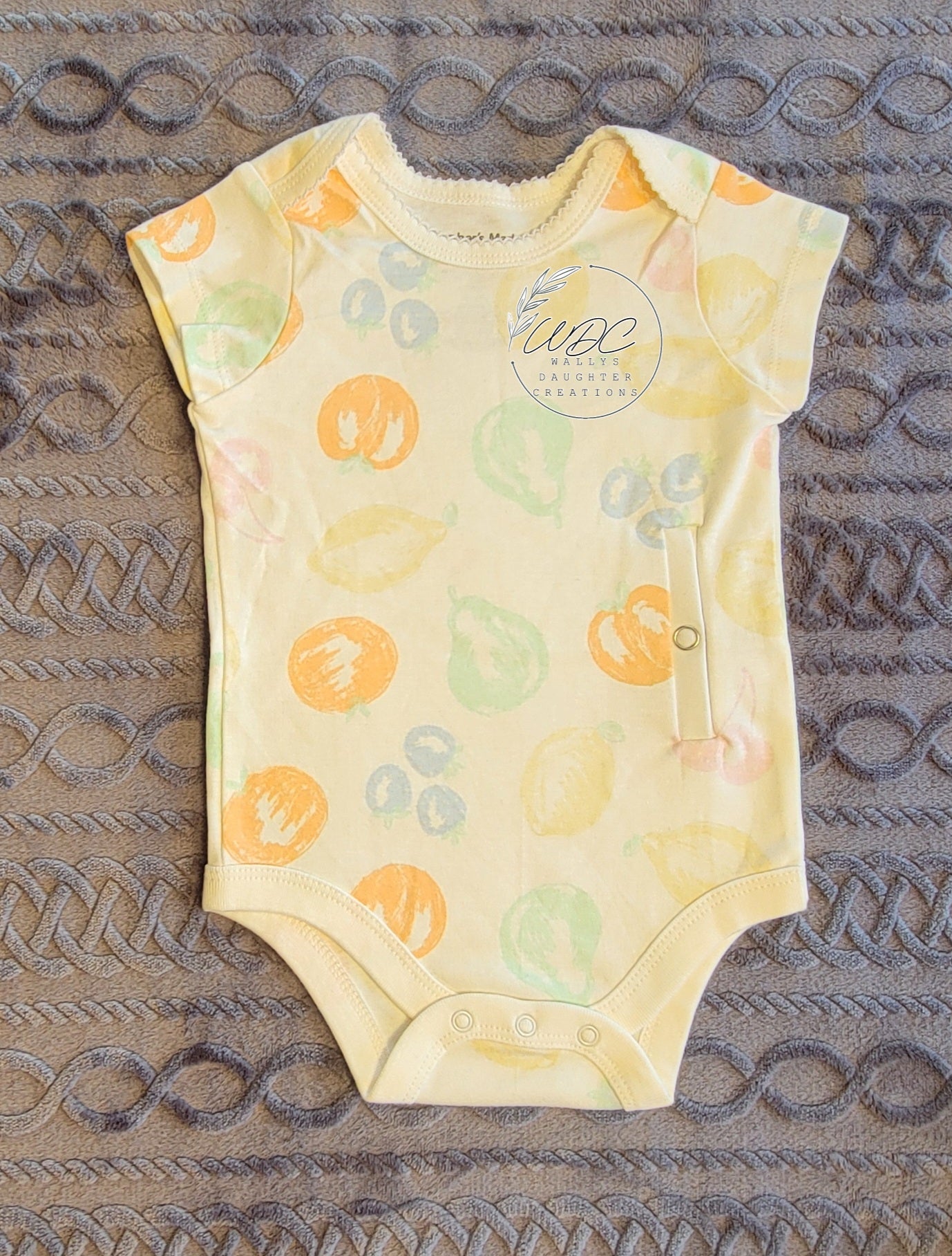 gtube adapted Baby onesie with fruit pattern on a textured surface