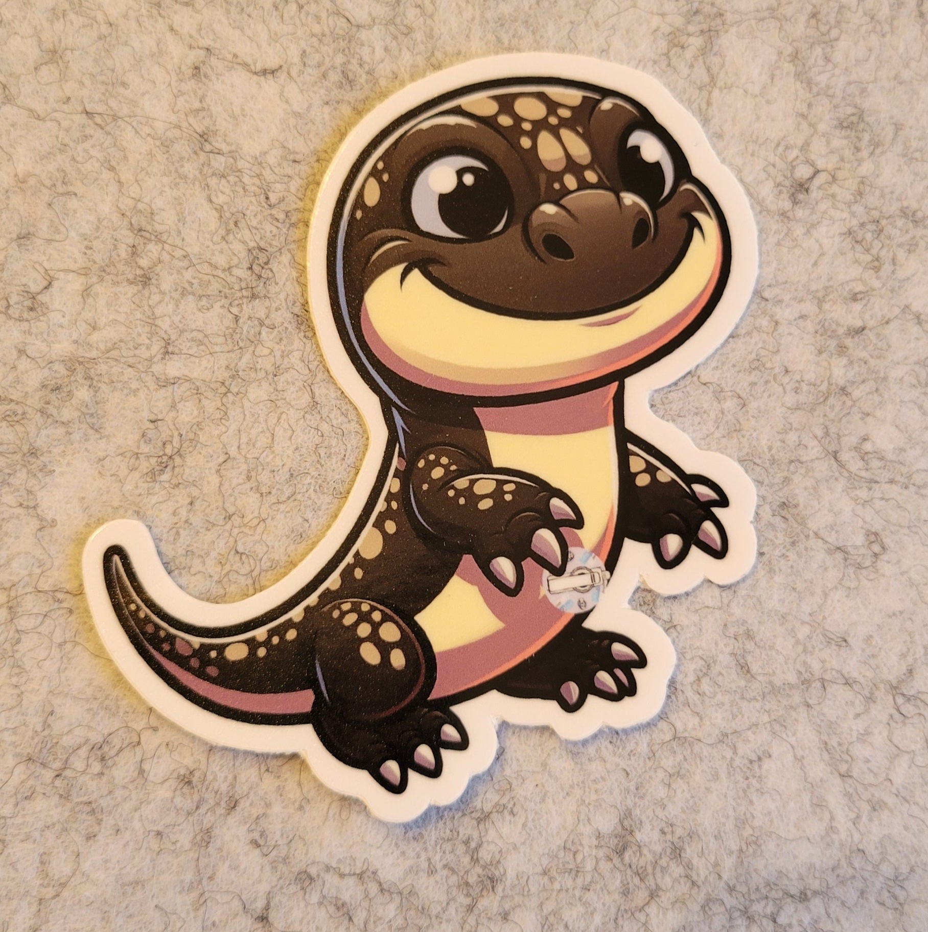 Cartoon salamander sticker on a textured surface