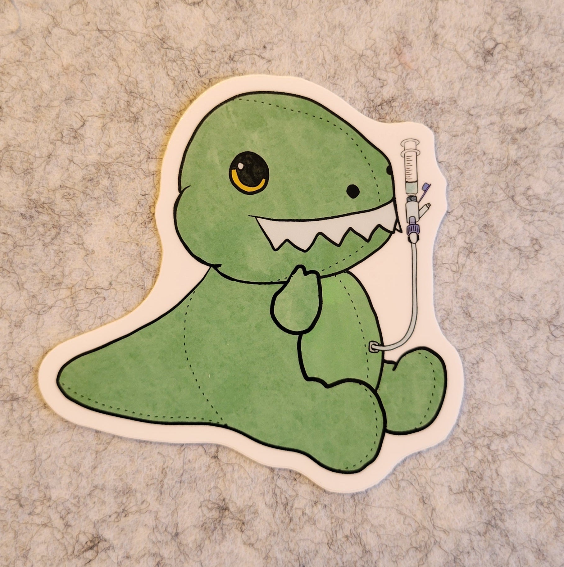 Green dinosaur sticker with a syringe on a textured surface