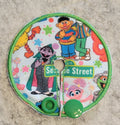 Gtube pad with Sesame Street characters and a street sign on a textured surface.
