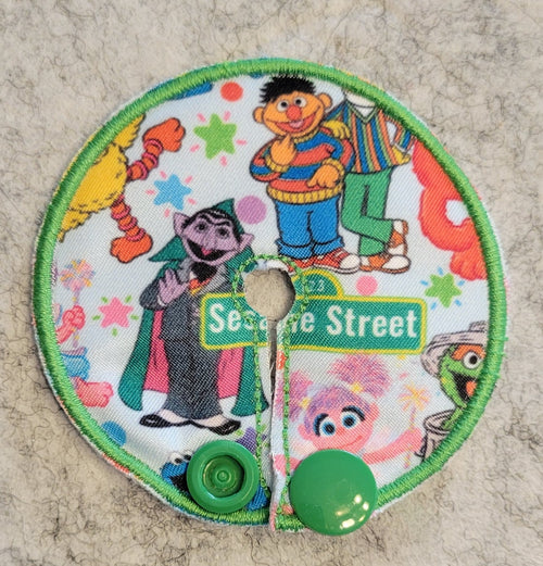 Gtube pad with Sesame Street characters and a street sign on a textured surface.