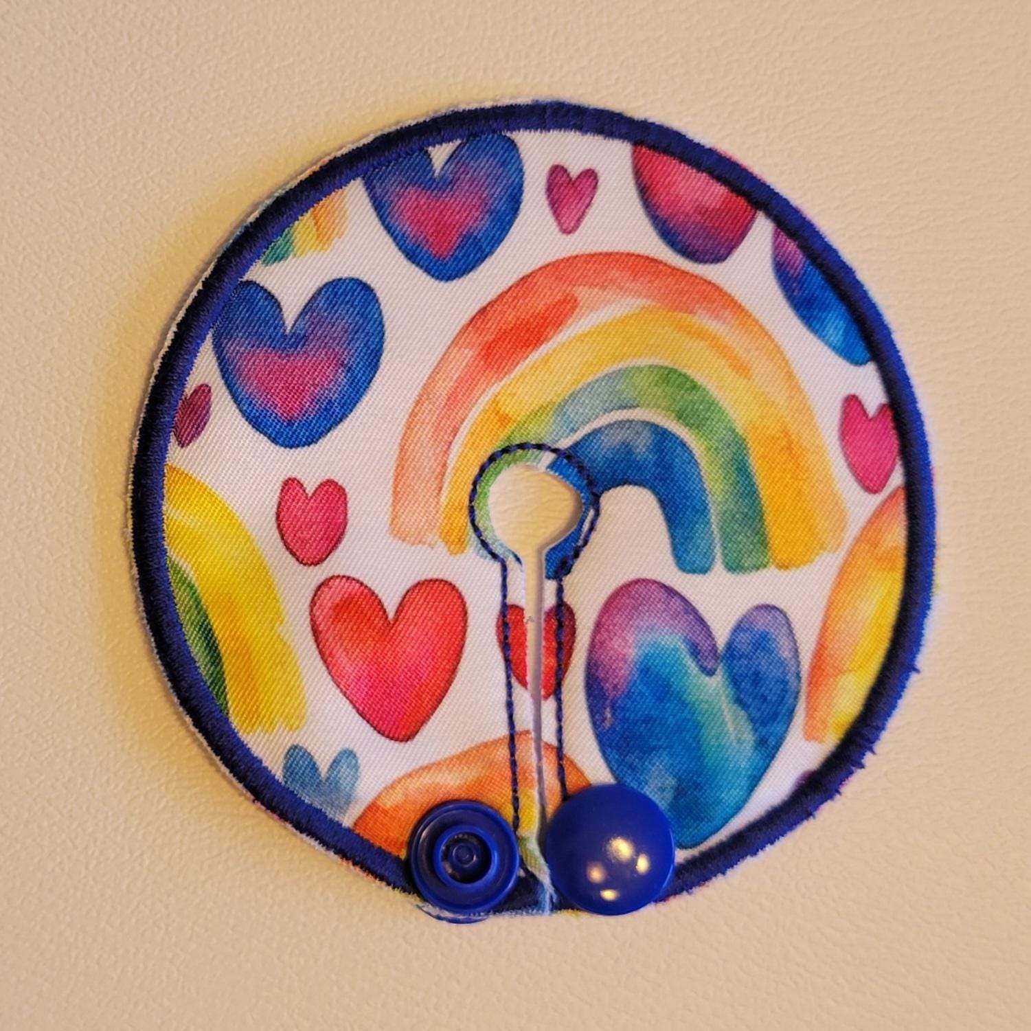 Circular patch with rainbow and heart design on a beige background