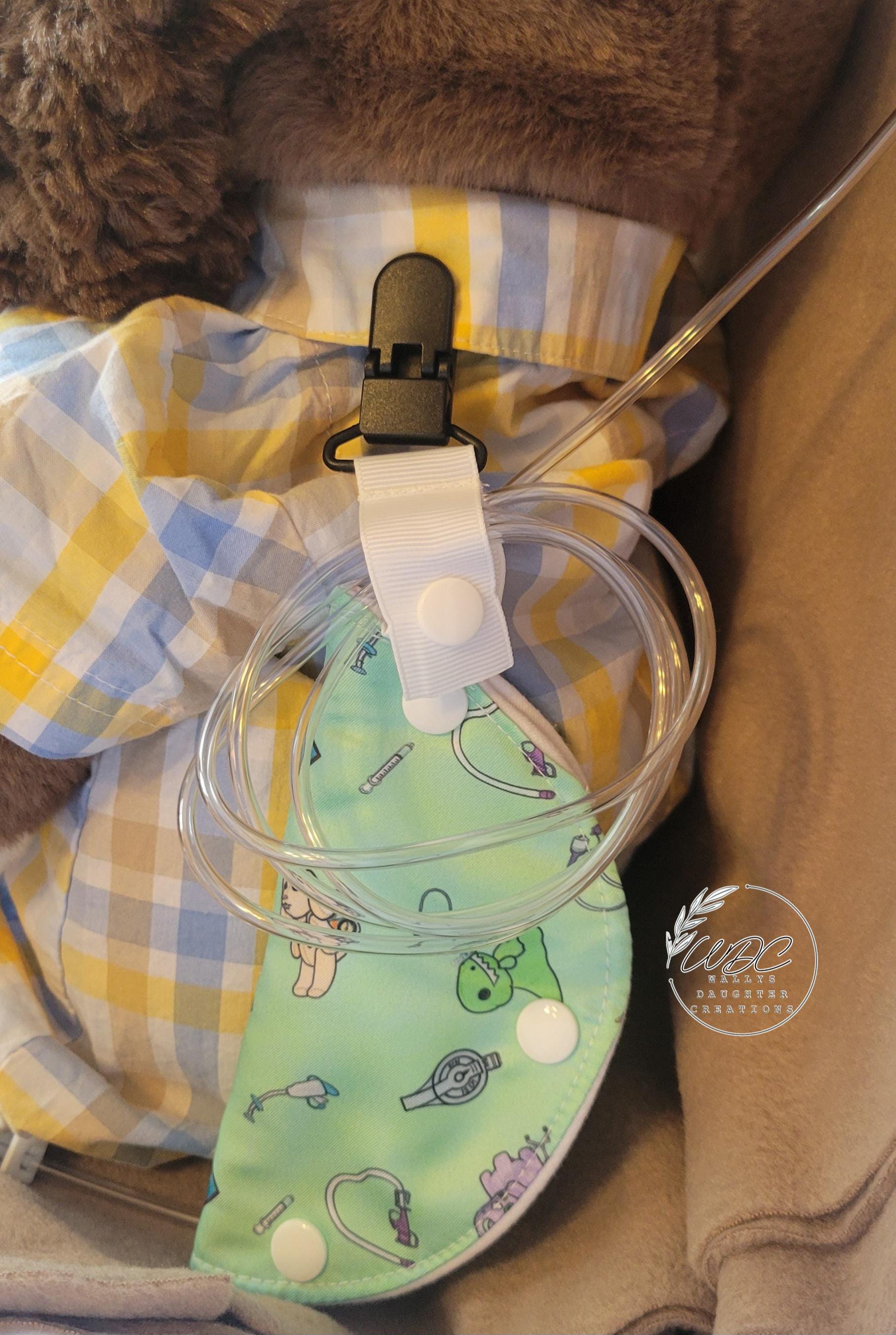 Clip on feeding tube port cover on a stuffed animal
