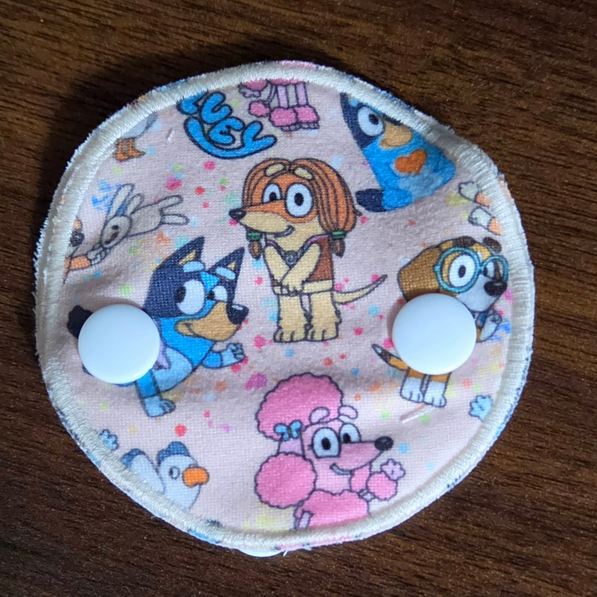 Snap down gtube pad with Aussie dog characters on beige background