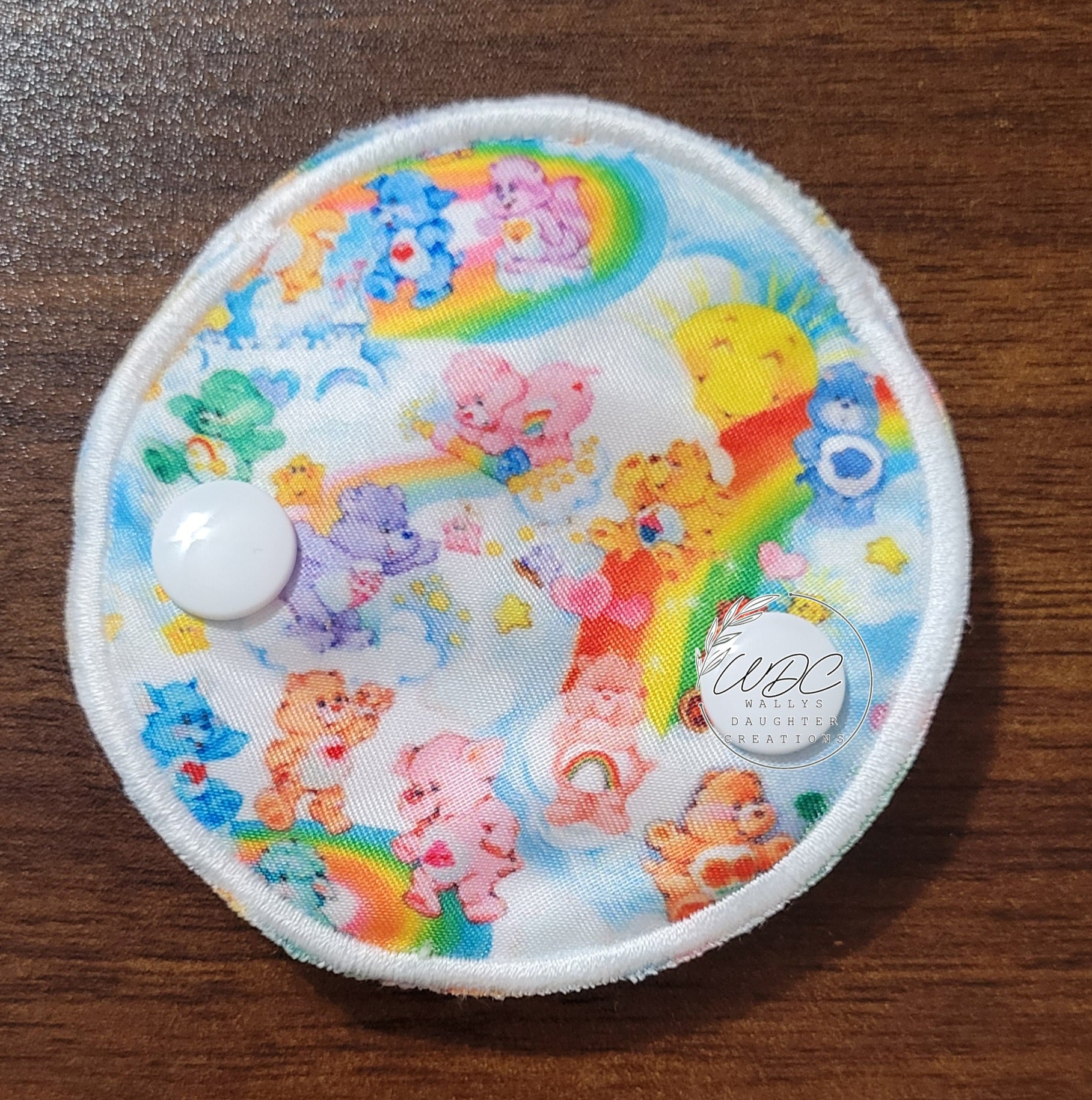 Snap down covered pad with pastel bears, sun and rainbows 