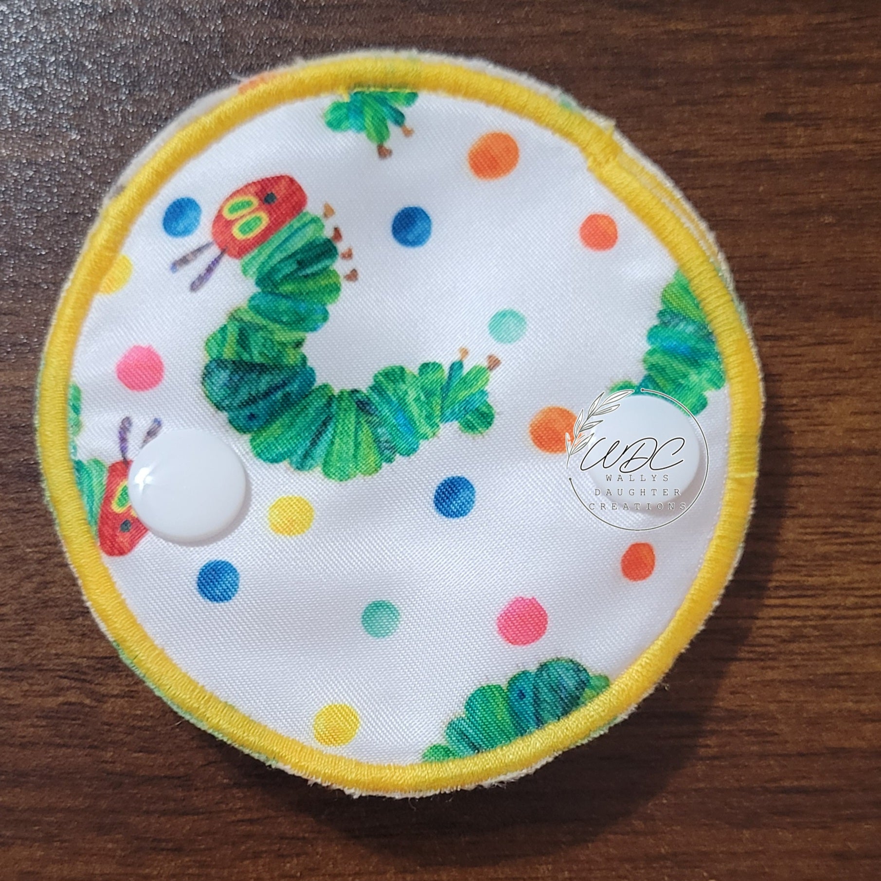 snap down covered pad with caterpillar character and multicolor polkadots