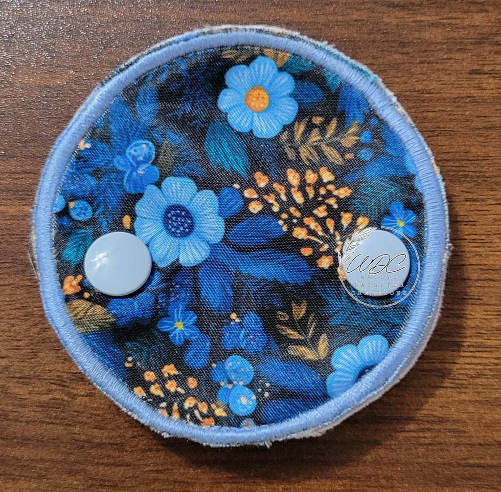 Snap down covered pad in blue floral with small gold floral spray on black background