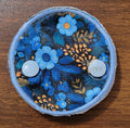 Snap down covered pad in blue floral with small gold floral spray on black background