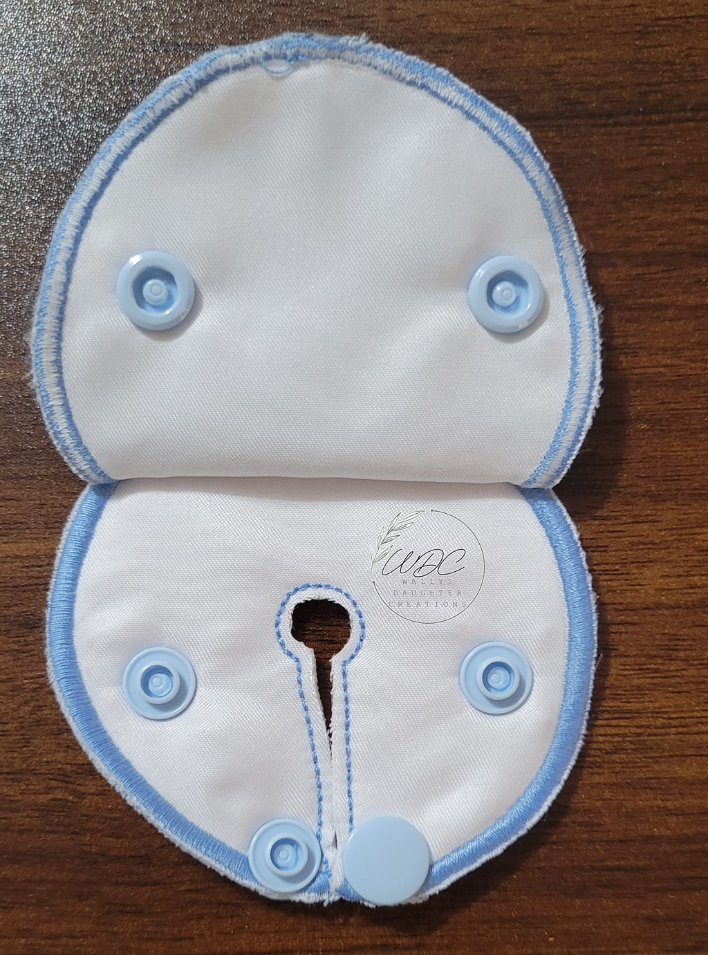 Snap down pad inside view with blue thread and snaps