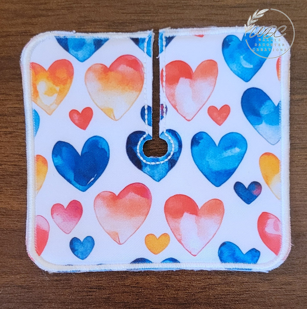 Trach pad with blue, red, and orange hearts on white background