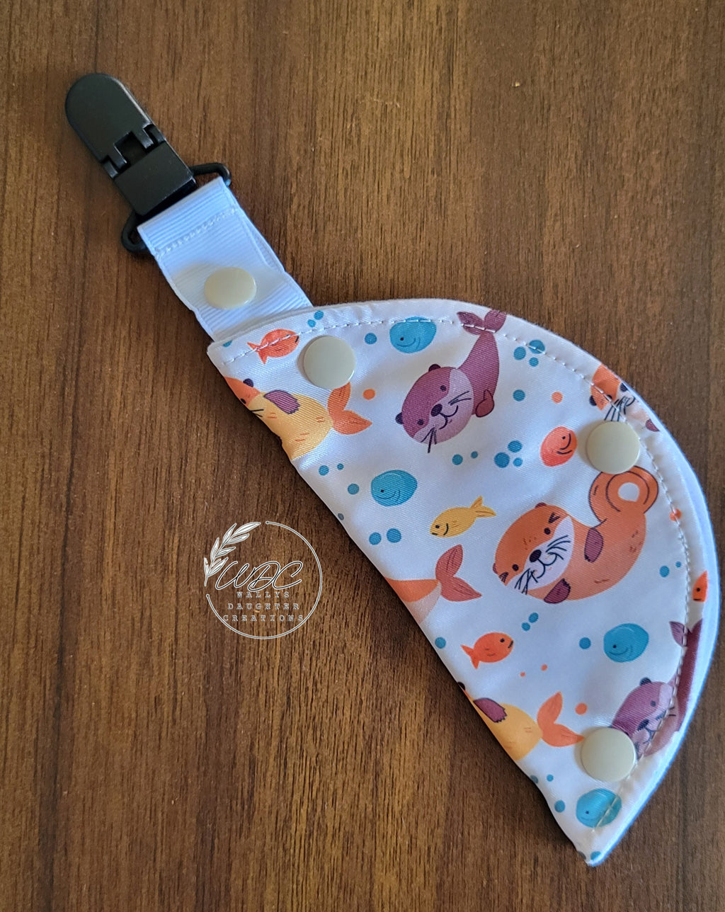 Clip on port cover with light and dark brown otters bubbles and fish