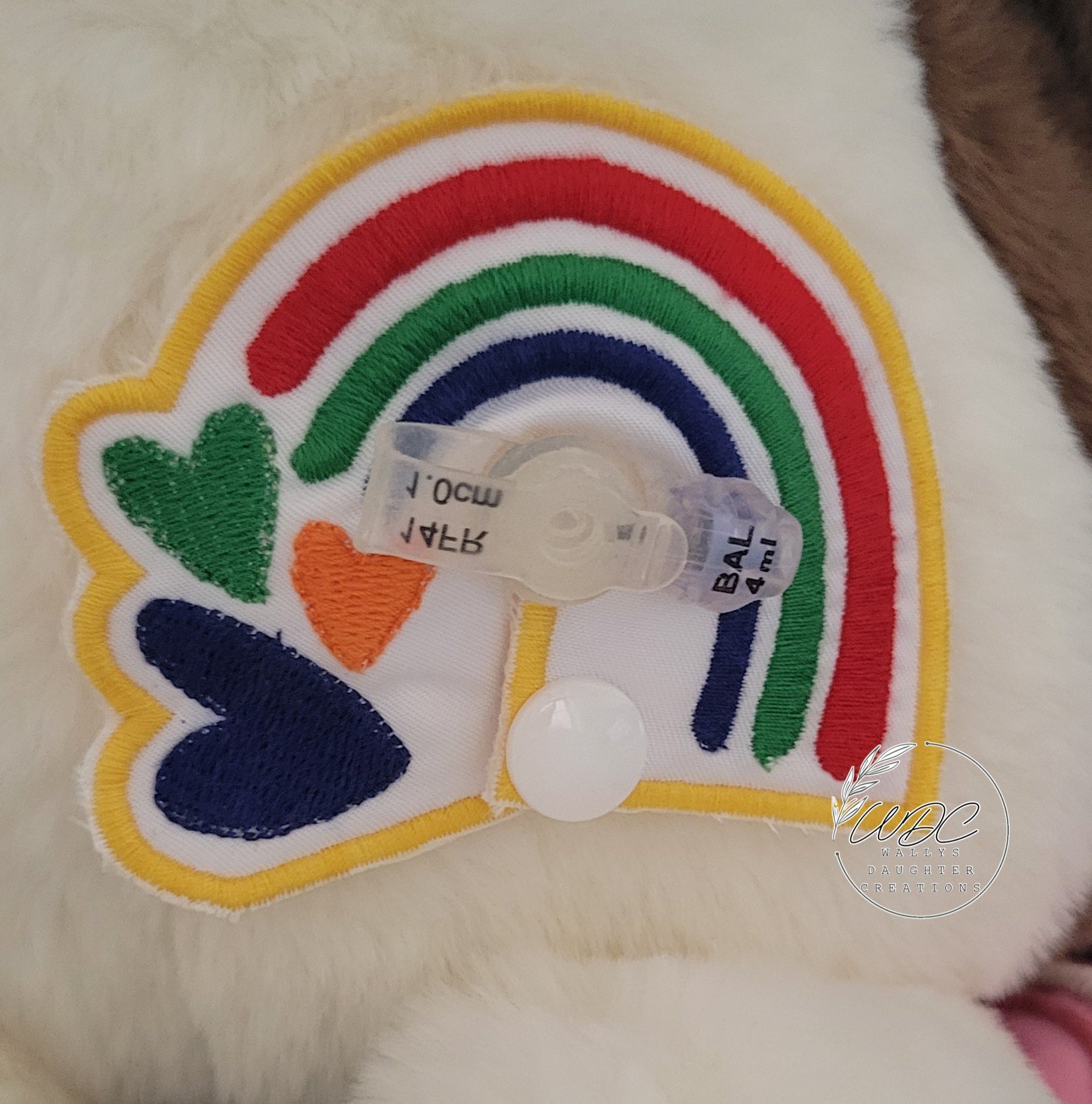 Primary Colored gtube pad around a mini tube button on a stuffie