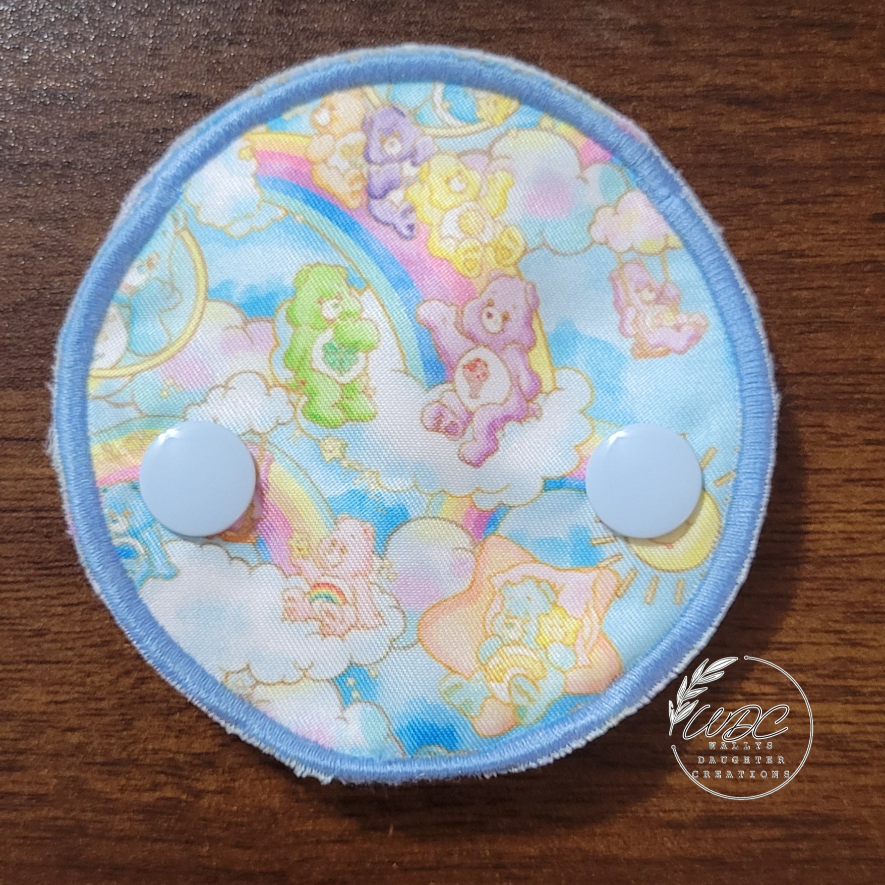 snap down covered pad with pastel bears and rainbows on clouds