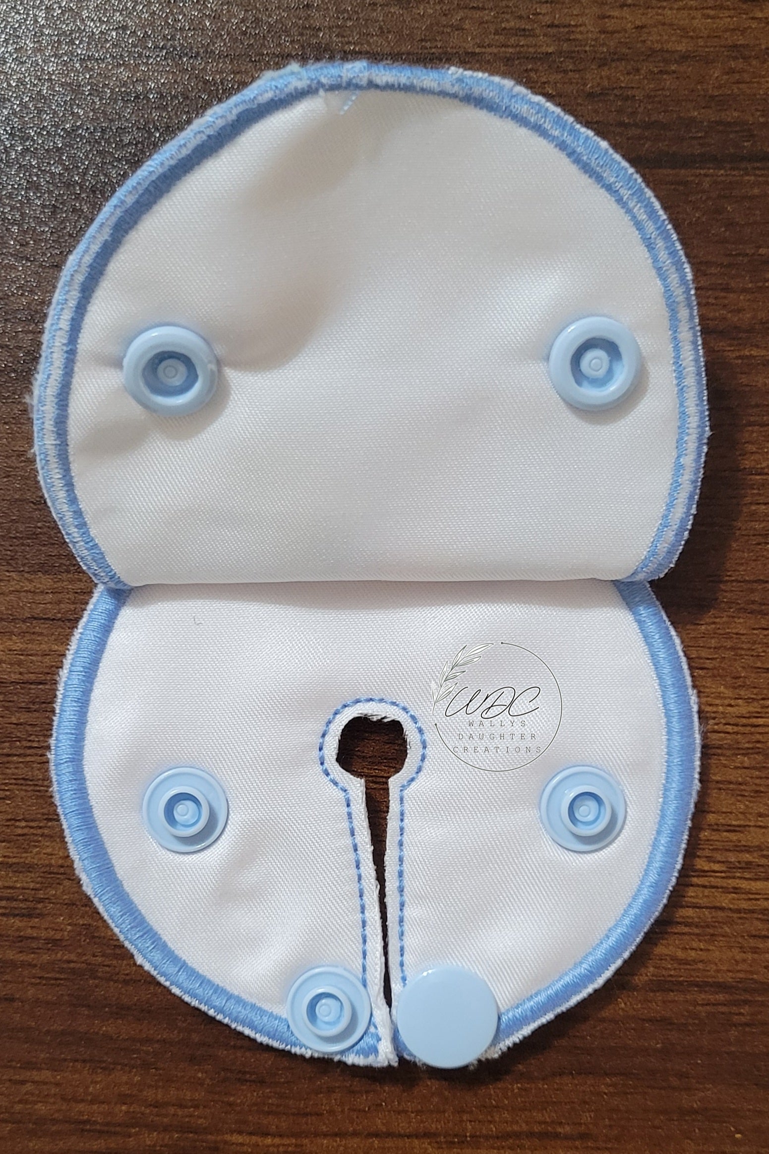 inside view of snap down pad with blue snaps and thread