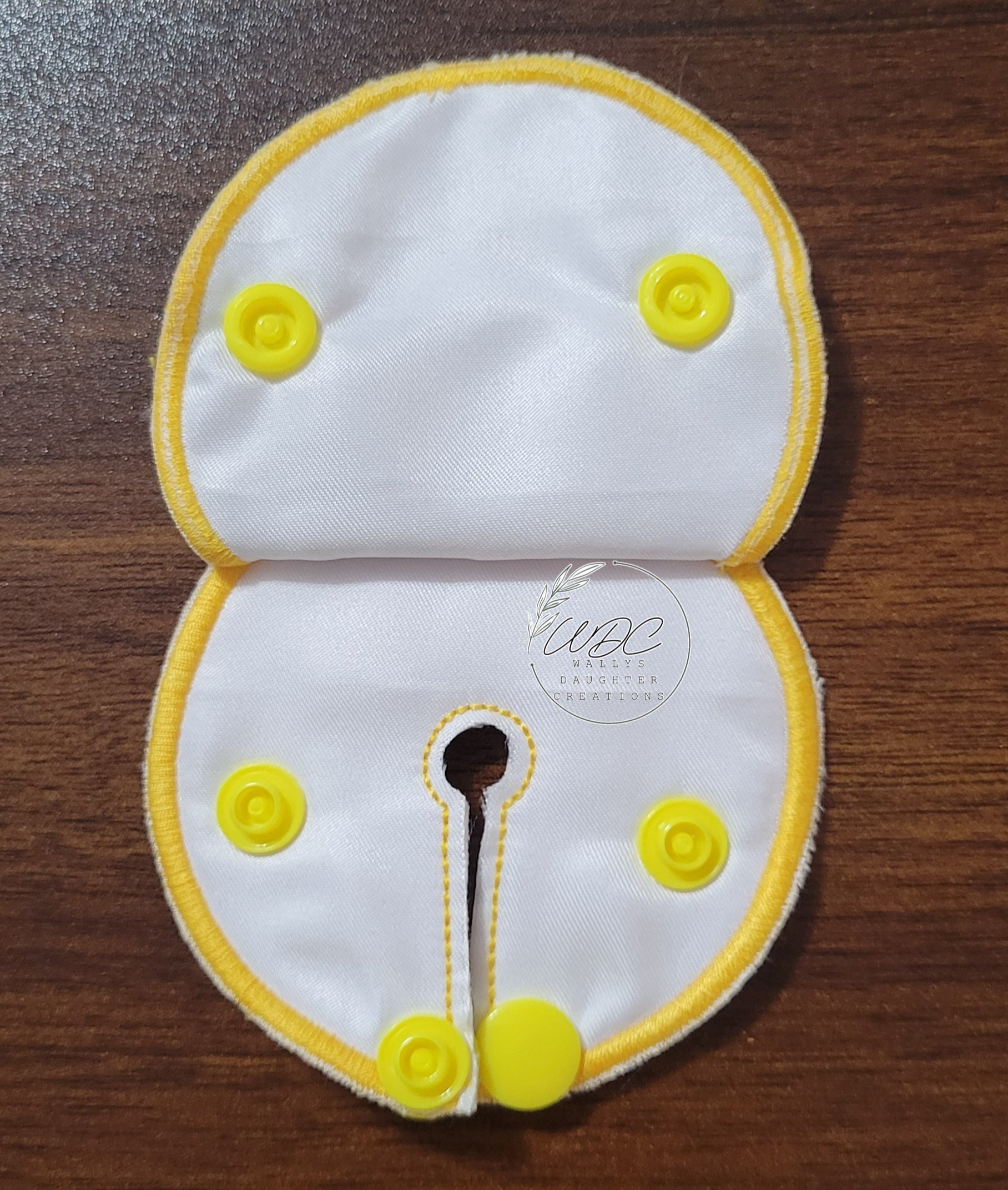 snap down covered pad inside view with yellow thread and snaps